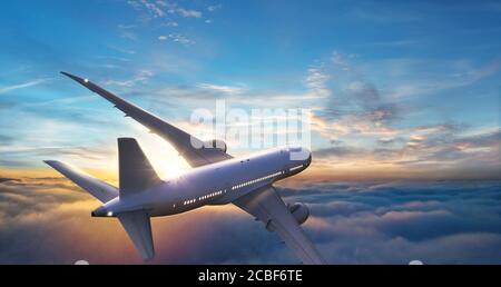 Passagers avion commercial volant au-dessus des nuages dans la lumière du coucher du soleil. Concept de voyage rapide, de vacances et d'affaires. Banque D'Images