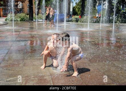 (200813) -- TIRANA, 13 août 2020 (Xinhua) -- les enfants se rafraîchissent dans les fontaines de la place Skanderbeg, au centre de la capitale Tirana, Albanie, le 12 août 2020. L'Albanie a été frappée mercredi par une vague de chaleur avec une température atteignant 39 degrés Celsius. Banque D'Images