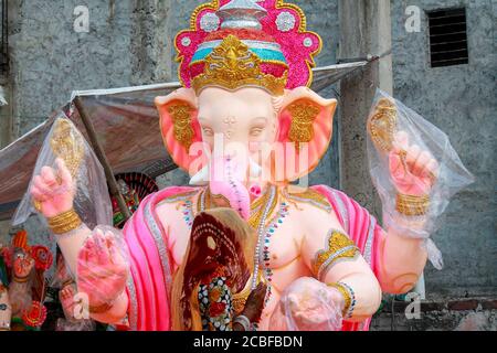 Artistes locaux de bord de route décorant la statue de dieu Ganesha en utilisant Plaster de peris pour la préparation de l'occasion religieuse ganesh chaturthi Banque D'Images