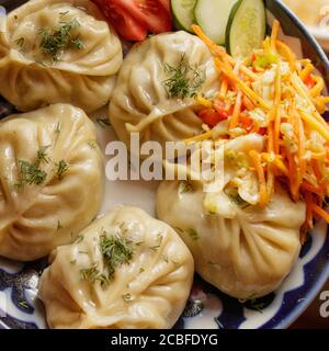 Plat traditionnel de manta orientale avec salade de légumes sur une assiette. Banque D'Images