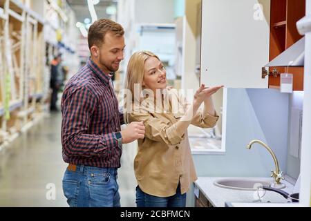 un couple attrayant veut mettre à mal leur ancienne cuisine, ils sont venus sur le marché pour acheter de nouvelles étagères de cuisine et d'autres choses Banque D'Images