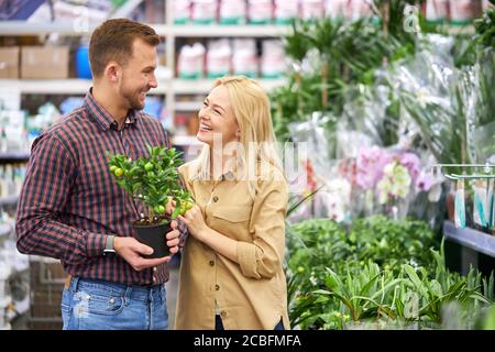 jeune beau couple marié est venu sur le marché pour acheter des plantes dans leur nouvelle maison, belle femme et beau gars dans l'amour. shopping ensemble Banque D'Images