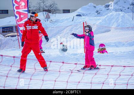 L'Alpe d'Huez, France 02.01.2019 un moniteur de ski professionnel enseigne à un enfant le ski par une journée ensoleillée sur une station de montagne. Vacances actives en famille et enfants. Banque D'Images