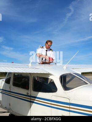 Un cliché vertical d'un homme avec des épaulettes remplissant les ailes de l'avion avec carburant à jet Banque D'Images