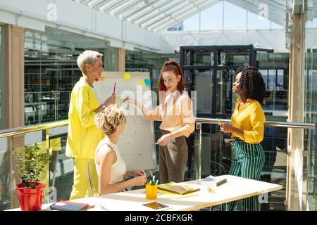 responsable émotif féminin dirigeant l'équipe d'entreprise, présentant des objectifs, coachant divers employés. gros plan. Banque D'Images