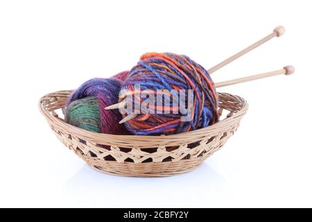 Panier avec deux boules de laine et aiguilles à tricoter Banque D'Images
