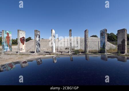 Teltow, Allemagne. 12 août 2020. Peint et pulvérisé avec des pièces de peinture du stand mural de Berlin sur un site industriel près du bassin du port sur le canal de Teltow. Au début des années 1990, une entreprise de construction de l'Armée populaire nationale a acheté les pièces murales. Des artistes et des profanes ont peint les parties en béton. Environ quarante des 170 parties qui ont autrefois constitué le mur sont maintenant restées. Credit: Soeren Stache/dpa-Zentralbild/ZB/dpa/Alay Live News Banque D'Images