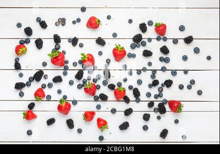 Fraises, bleuets et mûres sur bois blanc. Banque D'Images