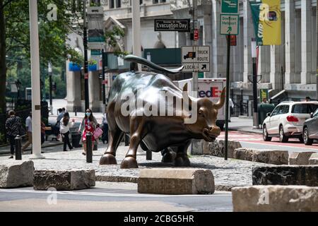 12 août 2020 : une femme portant un EPI passe devant le Bull de Wall Street à Manhattan, New York. Crédit obligatoire : Kostas Lymperopoulos/CSM Banque D'Images