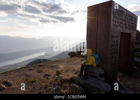 Garçon assis sur le rocher au coucher du soleil à côté de Garnet Gate sur Love Trail, Granattor, Lammersdorf Mountain, Nock Mountains, Carinthie, Autriche Banque D'Images