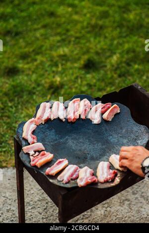 Bacon sur la poêle à frire. Tranches de bacon ou presse-purée cuits dans une poêle à frire. Banque D'Images