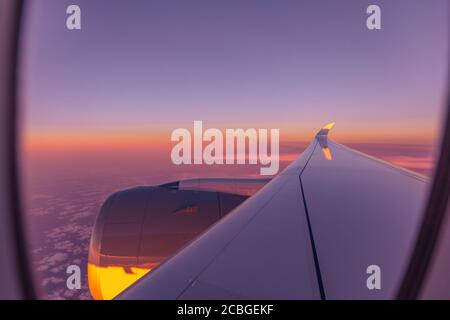 Belle vue panoramique sur la ville du coucher du soleil à travers la fenêtre de l'avion. Magnifique coucher de soleil, ciel la vue de dessus, avion vue de vol de l'intérieur de la fenêtre avion Banque D'Images