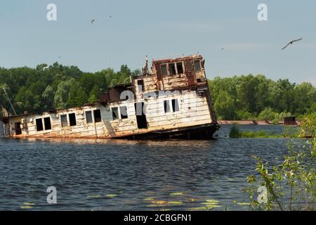 Une barge à moitié submergée avec un cimetière de navires sur la rivière Pripyat, Tchernobyl, Ukraine Banque D'Images