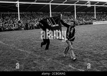 Tous les fans de Blacks qui s'exécutent sur le terrain avant leur match avec Llanelli RFC au parc de Stradey, Llanelli, le 21 octobre 1980. Banque D'Images