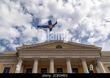 Drapeau d'État finlandais survolant un bâtiment du gouvernement à Helsinki Banque D'Images