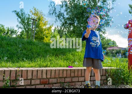 Enfant jouant avec un jouet bulle de savon. Mise au point sélective. Banque D'Images