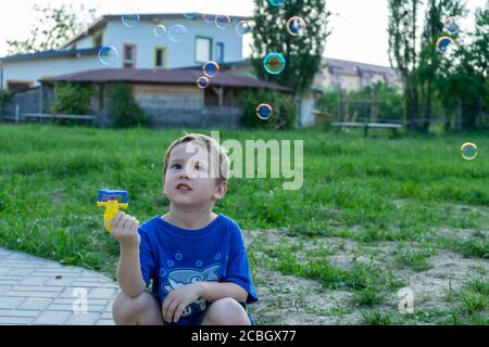 Enfant jouant avec un jouet bulle de savon. Mise au point sélective. Banque D'Images