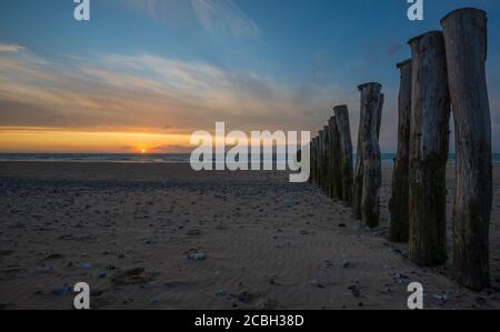 Clôture en bois sur la plage de Calais au coucher du soleil. Banque D'Images