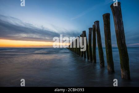 Clôture en bois sur la plage de Calais au coucher du soleil. Banque D'Images