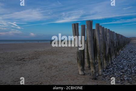 Clôture en bois sur la plage de Calais au coucher du soleil. Banque D'Images