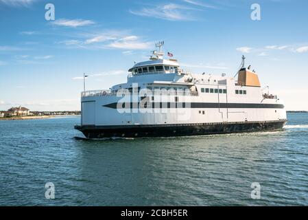 Ferry naviguant près de la côte lors d'une journée d'automne ensoleillée Banque D'Images