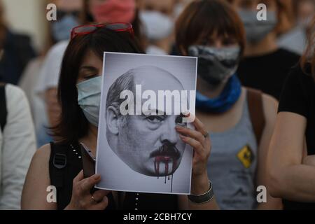 Manifestant tenant une image d'Alexandre Loukachenko qui a servi comme président de la Biélorussie depuis 1994, pendant la manifestation.des centaines de bélarussiens vivant à Cracovie et des partisans locaux se sont réunis pendant le rassemblement de solidarité organisé sur la place du marché de Cracovie à l'extérieur du monument Adam Mickiewicz contre le président biélorusse, Alexandre Loukachenko. Banque D'Images