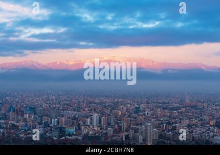 Horizon de Santiago du Chili au coucher du soleil avec les montagnes illuminées des Andes, Chili. Banque D'Images