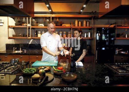 Istanbul, Turquie. 12 août 2020. Michael Riemenschneider (L), chef allemand étoilé au guide Michelin, donne des cours à un jeune chef dans son restaurant d'Istanbul, Turquie, le 12 août 2020. Après avoir passé près de quatre mois à la maison pendant les jours de quarantaine, le chef a ouvert les yeux sur un monde tout à fait nouveau où de nombreuses personnes ont commencé à aller à la région, à faire du shopping dans un magasin local, un boucher local, et à manger les produits des fermiers locaux. Credit: Osman Orsal/Xinhua/Alay Live News Banque D'Images