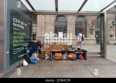 New York, États-Unis. 13 août 2020. Un chariot rempli de vêtements et de nourriture, ainsi que des boîtes en carton et des sacs poubelle, sont étalées sur un banc d'arrêt d'autobus dans le quartier de Chelsea, Manhattan, New York, NY, le 13 août 2020. Malgré la visite du maire de New York, Bill de Blasio, qui a affirmé que la question du sans-abrisme sera abordée, mais les résidents locaux et les propriétaires d'entreprises sont contrariés par les questions d'hygiène et de sécurité. (Anthony Behar/Sipa USA) crédit: SIPA USA/Alay Live News Banque D'Images