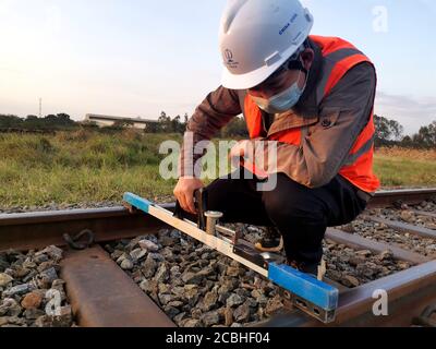 (200814) -- DAR ES SALAAM, le 14 août 2020 (Xinhua) -- l'ingénieur adjoint Zhang Guikai mesure les voies dans un site du projet de réhabilitation de la ligne ferroviaire centrale de la Tanzanie entrepris par la China civil Engineering Construction Corporation en Tanzanie le 5 août 2020. La ligne de chemin de fer centrale de Tanzanie a été construite il y a plus d'un siècle et a joué un rôle important en reliant ses provinces intérieures et les pays enclavés voisins aux ports maritimes. La China civil Engineering Construction Corporation (CCECC) réhabilite actuellement 985 kilomètres de la ligne existante du chemin de fer et répare son affiliat Banque D'Images