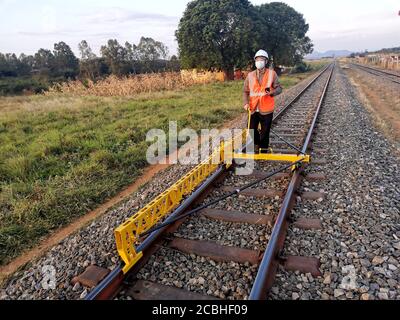 (200814) -- DAR ES SALAAM, le 14 août 2020 (Xinhua) -- l'ingénieur adjoint Zhang Guikai mesure les voies dans un site du projet de réhabilitation de la ligne ferroviaire centrale de la Tanzanie entrepris par la China civil Engineering Construction Corporation en Tanzanie le 5 août 2020. La ligne de chemin de fer centrale de Tanzanie a été construite il y a plus d'un siècle et a joué un rôle important en reliant ses provinces intérieures et les pays enclavés voisins aux ports maritimes. La China civil Engineering Construction Corporation (CCECC) réhabilite actuellement 985 kilomètres de la ligne existante du chemin de fer et répare son affiliat Banque D'Images