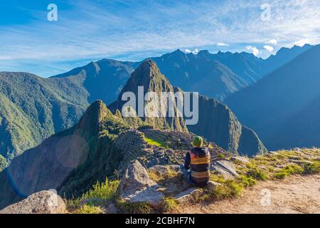 Touriste contemplant la ruine du Machu Picchu inca au lever du soleil, Cusco, Pérou. Banque D'Images