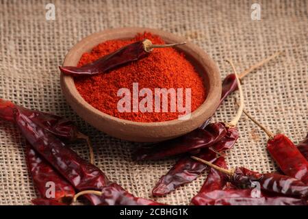 poudre de piment rouge avec piments rouges séchés. dans un bol en terre. Banque D'Images