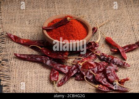 poudre de piment rouge avec piments rouges séchés. dans un bol en terre. Banque D'Images