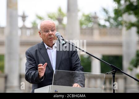Potsdam, Allemagne. 13 août 2020. Claus Peter Ladner, président de l'association de soutien 'Lindenstraße 54', parle à Glienicker Brücke à la mémoire de la construction du mur il y a 59 ans. En arrière-plan, vous pouvez voir les colonnades de grès flanquant le pont. La construction en acier au-dessus de la Havel était une interface hautement symbolique entre l'est et l'Ouest pendant la Guerre froide et était surtout connue comme un lieu où les agents échangeaient des voitures. Credit: Soeren Stache/dpa-Zentralbild/ZB/dpa/Alay Live News Banque D'Images
