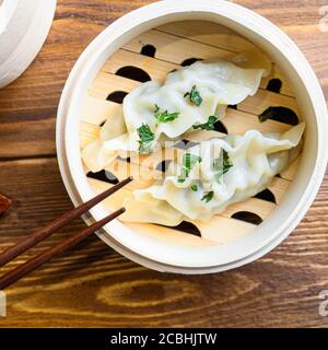 Faites cuire les aliments chinois du gyoza à la vapeur en gros plan table en bois Banque D'Images