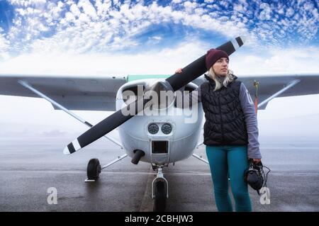 Le jeune pilote d'étudiant féminin de race blanche est debout devant Un avion à moteur unique Banque D'Images