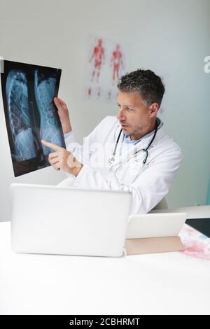 Le médecin discute de l'image radiologique par vidéoconférence avec son patient Banque D'Images