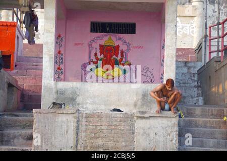 peinture murale ganesha et hommes locaux assis près du panch ganga ghat varanasi Banque D'Images