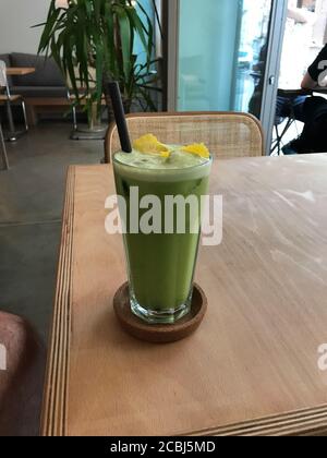 Jus de Detox vert au céleri, courgette de courgettes de courgettes de courgettes de courgettes de courgettes de pommes vertes Granny Smith, écorce de citron et glace en verre servis au restaurant. Froid biologique sain B Banque D'Images