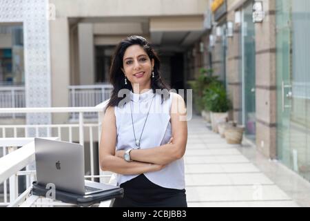Une femme indienne travaille sur son ordinateur portable dans un environnement urbain d'entreprise, Banque D'Images