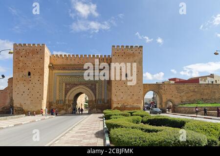 Meknes, Maroc - Okt.17,2018:mur de la vieille ville avec porte Bab el-Khemis, entrée de la vieille ville. Les gens qui marchent et les vieilles voitures y conduisent. Avec un ciel bleu Banque D'Images