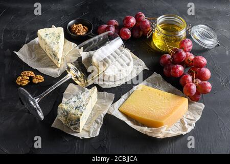 Assortiment de fromages, un verre de vin sauvignon blanc, du miel, une sélection de hors-d'œuvre aux noix ou un assortiment de collations à la baleine fromages moulés Camémbert figues fraîches Banque D'Images