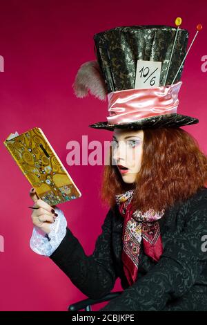 Portrait de la jeune femme à l'image du Hatter lecture d'un livre avec émotion surprise Banque D'Images