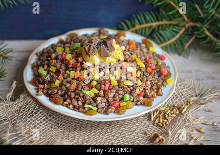 Pilaf sucré aux fruits secs. Kutia moderne aux fruits confits. Assiette avec kutia et fruits secs. Bouillie de Noël aux raisins secs, orange confite Banque D'Images