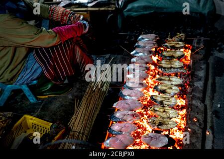 L'image de poissons frais de pêcheurs grillés sur des émonteurs à vendre sur le marché de Dien Van, village de poissons grillés, province de Nghe an, Vietnam Banque D'Images