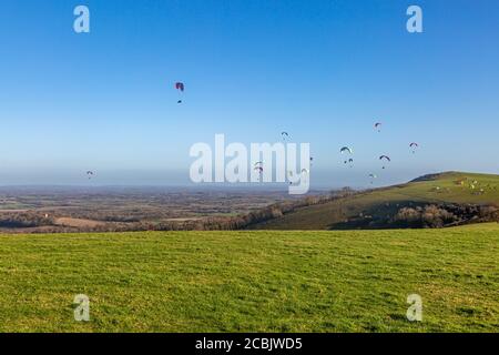 Parapente dans le ciel au-dessus de Firle Beacon dans les South Downs, lors d'une journée hivernale ensoleillée Banque D'Images