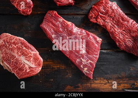 Bio Flank bavette ou rabats steak t steak près les huîtres à trois pointes et à lames supérieures se coupent de près devant d'autres coupes dans la boucherie sur le vieux plan de table en bois Banque D'Images