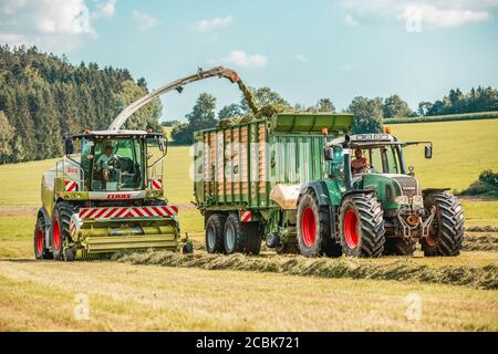 BAVIÈRE / ALLEMAGNE - AOÛT 07,2020 : la moissonneuse Claas Jaguar 930 et un Fendt 926 avec remorque Krone ZX400GL travaillent dans un champ. Banque D'Images