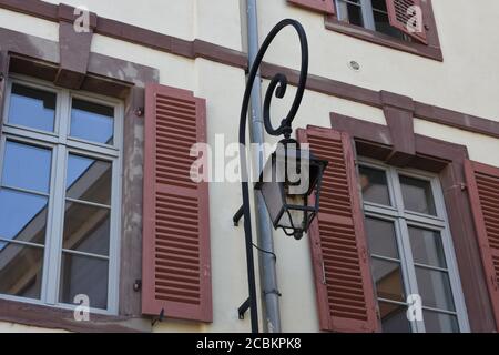 Verre brisé d'une vieille lampe de rue avec une nouvelle ampoule dans la façade d'un ancien bâtiment résidentiel dans le centre de Colmar, France. Banque D'Images